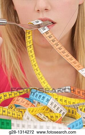 Young blond woman with long hair eating a colored tape out of a plate to evoke the concept of diet and weight problems, concept image detail View Large Photo Image Stock Image - Young blond woman with long hair eating a colored tape out of a plate to evoke the concept of diet and weight problems, concept image detail. Fotosearch