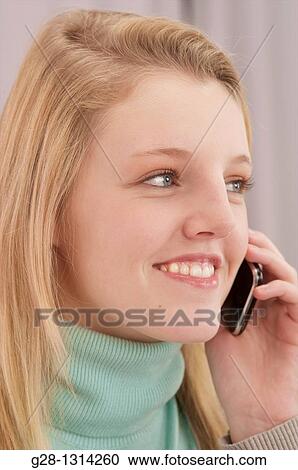 young blond woman with long hair using a cell phone and smiling View Large Photo Image Stock Image - young blond woman with long hair using a cell phone and smiling. Fotosearch