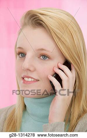 Young blond woman with long hair using a cell phone and smiling View Large Photo Image Stock Photo - Young blond woman with long hair using a cell phone and smiling. Fotosearch