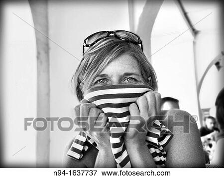 Young blond woman with sunglasses on head, covering her face with a shirt. View Large Photo Image Stock Photo - Young blond woman with sunglasses on head, covering her face with a shirt.. Fotosearch