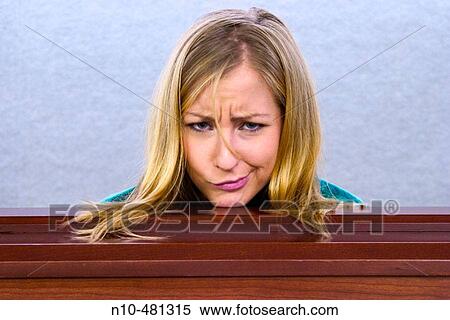 Stock Photography - Young blond woman's head resting on a ledge in an office building.. Fotosearch