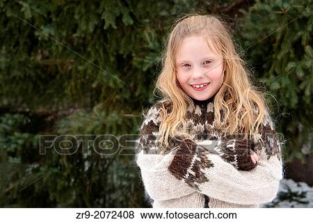 Young blonde girl dressed in a woolen sweater hugs self to keep warm outdoors on a winter day. View Large Photo Image Stock Photo - Young blonde girl dressed in a woolen sweater hugs self to keep warm outdoors on a winter day.. Fotosearch