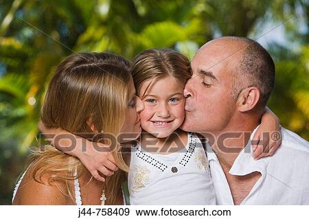 Young blonde girl embracing father and mother outdoors, smiling, portrait View Large Photo Image Stock Photo - Young blonde girl embracing father and mother outdoors, smiling, portrait. Fotosearch