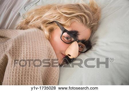 Young blonde girl in bed, wearing funny glasses View Large Photo Image Stock Photo - Young blonde girl in bed, wearing funny glasses. Fotosearch