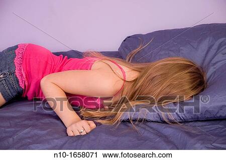 Young blonde girl lying on her bed View Large Photo Image Stock Image - Young blonde girl lying on her bed. Fotosearch