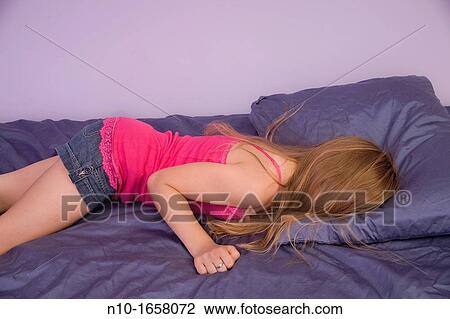 Young blonde girl lying on her bed View Large Photo Image Stock Image - Young blonde girl lying on her bed. Fotosearch