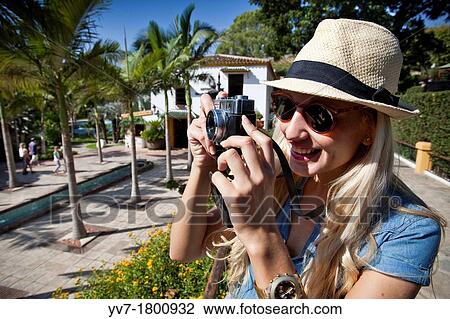 Young blonde girl taking pictures in the Molino de Inca Botanical Garden View Large Photo Image Stock Image - Young blonde girl taking pictures in the Molino de Inca Botanical Garden. Fotosearch