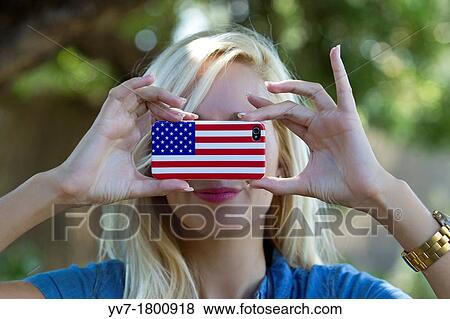 Young blonde girl taking pictures with an iPhone decorated with American flag View Large Photo Image Stock Photo - Young blonde girl taking pictures with an iPhone decorated with American flag. Fotosearch