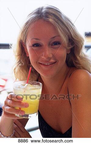 Stock Photograph - Young blonde girl with cocktail. Fotosearch