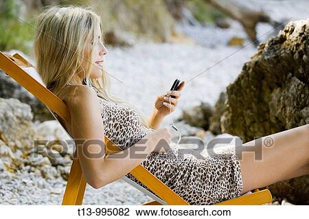 Young blonde is listening music on the beach View Large Photo Image Stock Image - Young blonde is listening music on the beach. Fotosearch