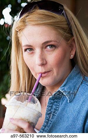 Young blonde woman drinking a latte in a plastic cup. View Large Photo Image Stock Image - Young blonde woman drinking a latte in a plastic cup.. Fotosearch