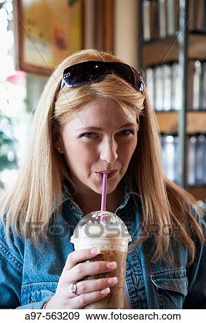 Young blonde woman drinking a latte in a plastic cup. View Large Photo Image Stock Photo - Young blonde woman drinking a latte in a plastic cup.. Fotosearch