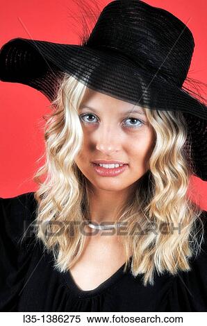 Young blonde woman in a black hat against a red background View Large Photo Image Stock Photography - Young blonde woman in a black hat against a red background. Fotosearch