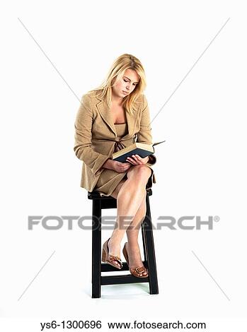 Young blonde woman in business suit reading a book sitting on a stool View Large Photo Image Stock Photograph - Young blonde woman in business suit reading a book sitting on a stool. Fotosearch
