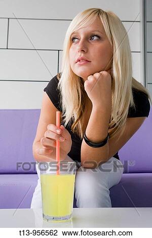 Young blonde woman is mixing a drink with a plastic straw View Large Photo Image Stock Image - Young blonde woman is mixing a drink with a plastic straw. Fotosearch