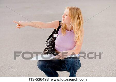Young blonde woman is pointing to the right direction after examining a road map View Large Photo Image Stock Image - Young blonde woman is pointing to the right direction after examining a road map. Fotosearch