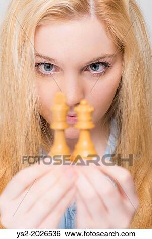 Young blonde woman looking closely at chess pieces. View Large Photo Image Stock Photograph - Young blonde woman looking closely at chess pieces.. Fotosearch