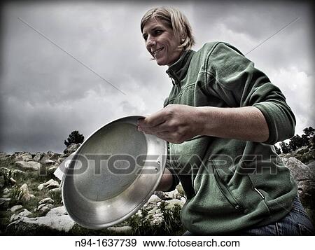 Young blonde woman preparing aluminum plates on the mountain. View Large Photo Image Stock Photo - Young blonde woman preparing aluminum plates on the mountain.. Fotosearch