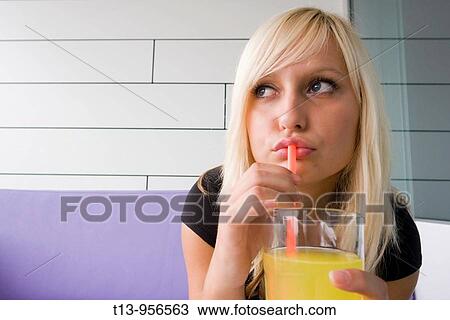 Young blonde woman with a glass of drink View Large Photo Image Stock Image - Young blonde woman with a glass of drink. Fotosearch