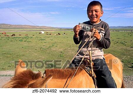 Young Boy Age 12 on Horse Holding First American Dollar in the Nomadic Country of Mongolia. View Large Photo Image Stock Image - Young Boy Age 12 on Horse Holding First American Dollar in the Nomadic Country of Mongolia.. Fotosearch