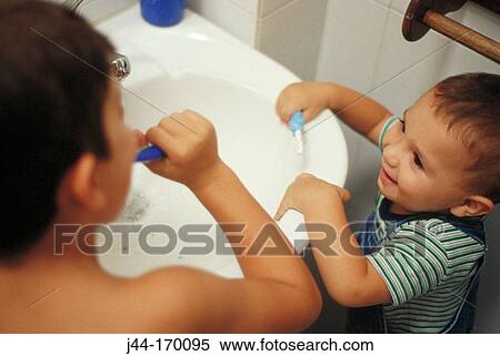 Young boy and infant boy brushing their teeth in the bathroom View Large Photo Image Stock Photography - Young boy and infant boy brushing their teeth in the bathroom. Fotosearch
