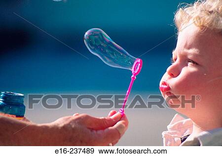 Stock Photo - young boy blowing bubbles. Fotosearch