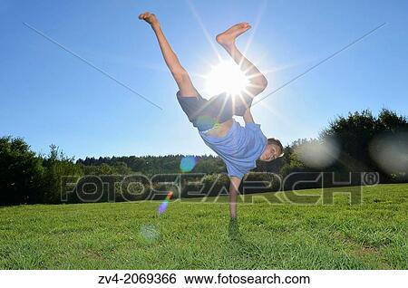 Young boy doing a handstand on a meadow, Germany. View Large Photo Image Stock Photograph - Young boy doing a handstand on a meadow, Germany.. Fotosearch