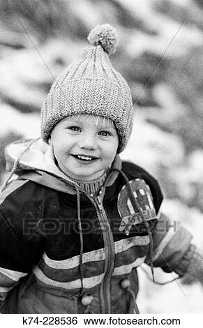 Stock Photograph - young boy dressed for winter, smiling. Fotosearch