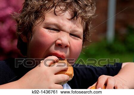 Young boy eating a hamburger. View Large Photo Image Stock Image - Young boy eating a hamburger.. Fotosearch