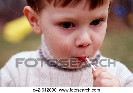 Stock Image - Young boy eating lollipop. Fotosearch