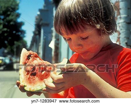 Stock Photo - young boy enjoying a huge slice of watermelon. Fotosearch