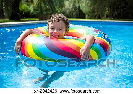 Stock Photograph - Young boy enjoys summer in the pool.. Fotosearch