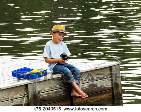 Stock Photography - Young boy fishing off dock. Fotosearch