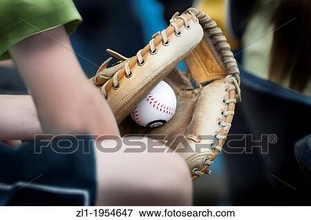 Stock Photo - Young boy holding baseball glove with ball in the mitt.. Fotosearch