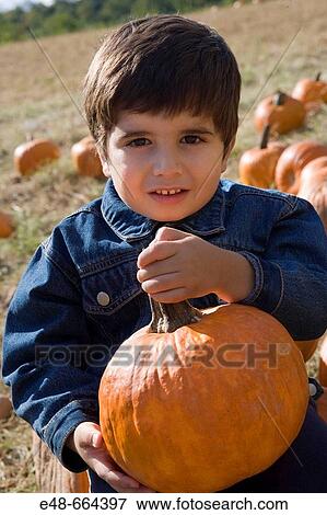 Young boy holding pumpkin in pumpkin patch View Large Photo Image Stock Photo - Young boy holding pumpkin in pumpkin patch. Fotosearch
