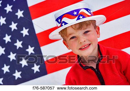 Stock Photo - Young boy in patriotic hat in front of an American flag.. Fotosearch