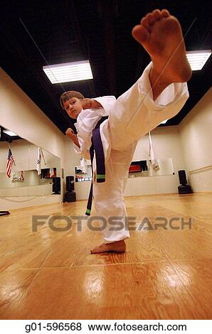 Young boy karate kicking in a karate studio View Large Photo Image Stock Photo - Young boy karate kicking in a karate studio. Fotosearch