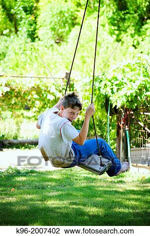 Young boy making faces while swinging View Large Photo Image Stock Image - Young boy making faces while swinging. Fotosearch