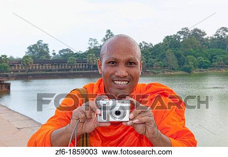 Young boy monk playing with camera and smile having fun at river at famous Angkor Wat in Siem Reap Cambodia in Asia View Large Photo Image Stock Image - Young boy monk playing with camera and smile having fun at river at famous Angkor Wat in Siem Reap Cambodia in Asia. Fotosearch