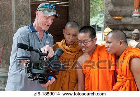 Young boy monks laughing and having fun looking at TV video of themselves from photographer in Siem Reap in Cambodia Asia relaxing and being boys View Large Photo Image Picture - Young boy monks laughing and having fun looking at TV video of themselves from photographer in Siem Reap in Cambodia Asia relaxing and being boys. Fotosearch