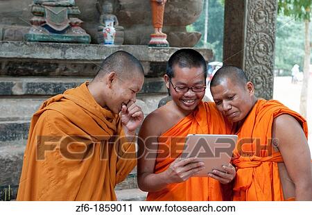 Young boy monks laughing and having fun at Apple Digital Tablet computer game in Siem Reap in Cambodia Asia relaxing and being boys View Large Photo Image Stock Image - Young boy monks laughing and having fun at Apple Digital Tablet computer game in Siem Reap in Cambodia Asia relaxing and being boys. Fotosearch