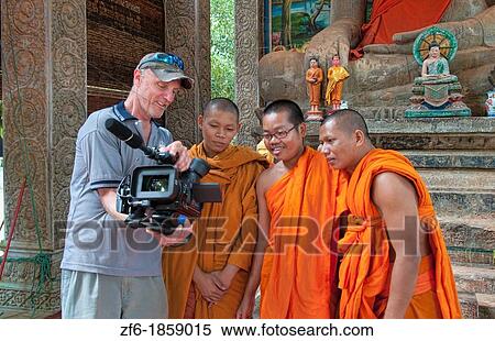 Young boy monks laughing and having fun looking at TV video of themselves from photographer in Siem Reap in Cambodia Asia relaxing and being boys View Large Photo Image Stock Photography - Young boy monks laughing and having fun looking at TV video of themselves from photographer in Siem Reap in Cambodia Asia relaxing and being boys. Fotosearch