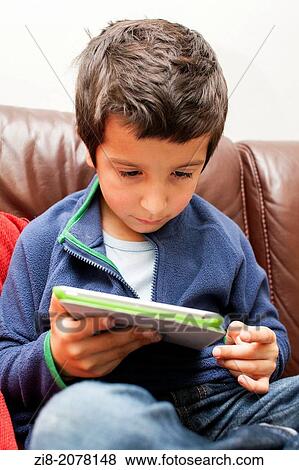 Young boy on a tablet tablet. View Large Photo Image Stock Photo - Young boy on a tablet tablet.. Fotosearch