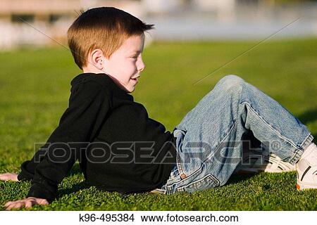 young boy on grass View Large Photo Image Picture - young boy on grass. Fotosearch