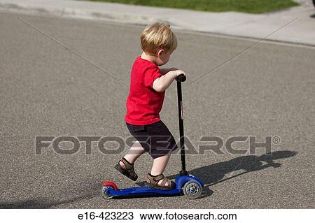 Young boy on scooter View Large Photo Image Stock Image - Young boy on scooter. Fotosearch