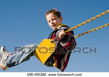young boy on swing View Large Photo Image Stock Image - young boy on swing. Fotosearch