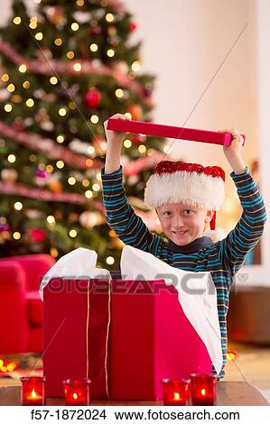 Young boy opening a Christmas present on Christmas day View Large Photo Image Picture - Young boy opening a Christmas present on Christmas day. Fotosearch