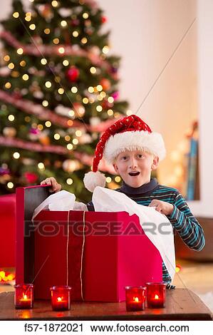 Stock Image - Young boy opening a Christmas present on Christmas day. Fotosearch