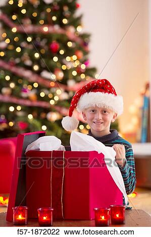 Young boy opening a Christmas present on Christmas day View Large Photo Image Stock Image - Young boy opening a Christmas present on Christmas day. Fotosearch