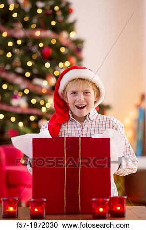 Young boy opening a Christmas present on Christmas day View Large Photo Image Stock Image - Young boy opening a Christmas present on Christmas day. Fotosearch